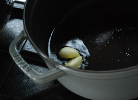 厚手の鍋ににんにくとオイルを入れて、弱火でじっくりと熱します